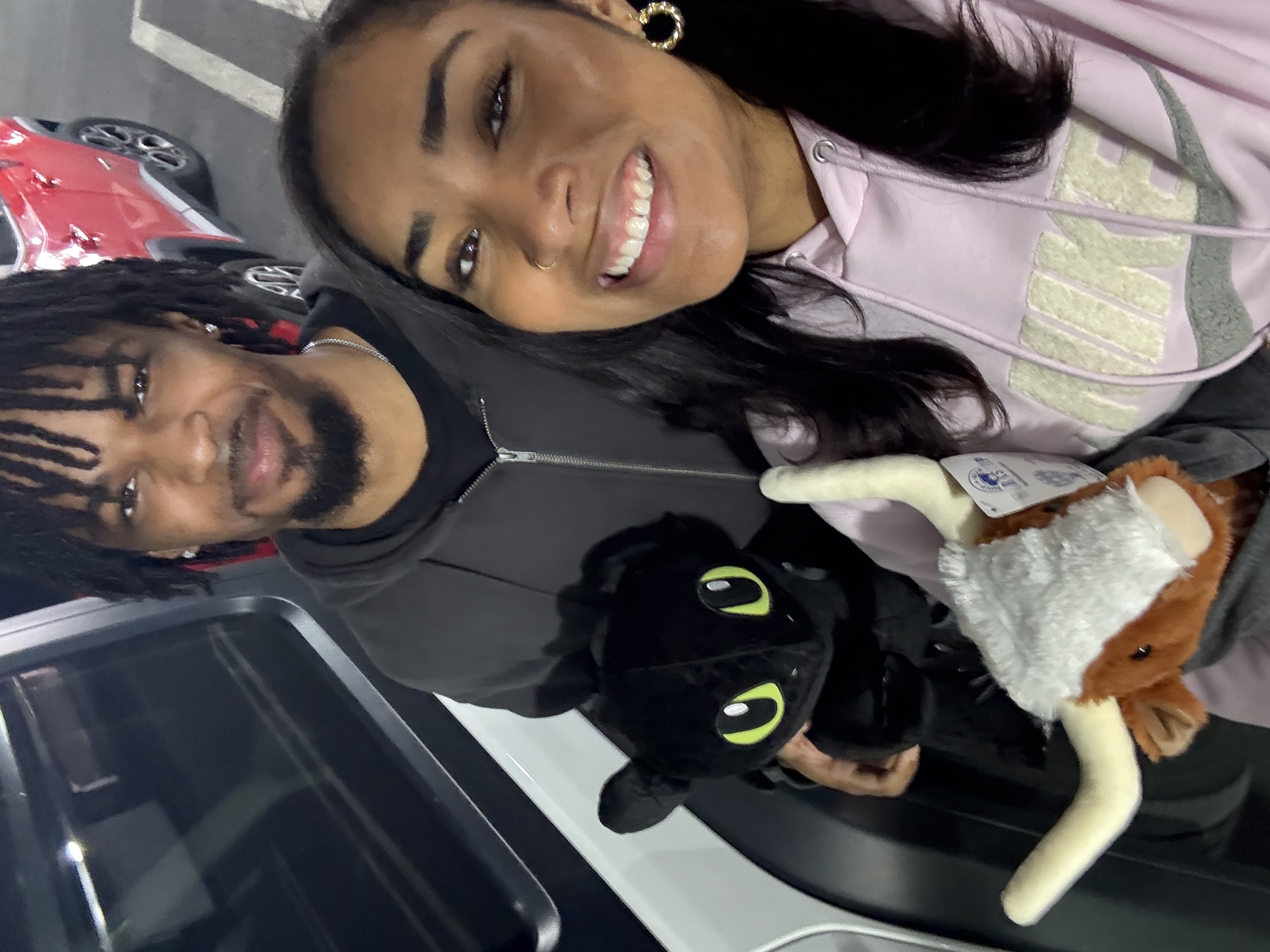Jaden and his girlfriend smiling together while holding stuffed animals